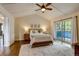 Bedroom featuring wood floors, ceiling fan, sliding glass doors to the patio, and decorated with wall art at 3142 Captains Ln, Longmont, CO 80503