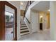 Inviting entryway features tiled floors, staircase, and natural light from the wood-framed glass door to the backyard patio at 3142 Captains Ln, Longmont, CO 80503