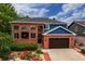 Beautiful two-story red brick home with blue accents and a well-manicured front yard and a two car garage at 3142 Captains Ln, Longmont, CO 80503