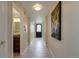 Well-lit hallway with tile floors leads to a decorative front door, featuring modern art and a glimpse of the bathroom at 3142 Captains Ln, Longmont, CO 80503