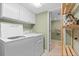 Basement laundry room with washer, dryer, and cabinets at 2602 S Lafayette St, Denver, CO 80210