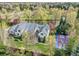 An aerial view shows the home, the basketball court, and the lush surrounding landscape at 1075 E Oxford Ln, Cherry Hills Village, CO 80113