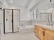 Bright bathroom featuring tiled floor, glass shower, soaking tub, and ample vanity space at 1075 E Oxford Ln, Cherry Hills Village, CO 80113