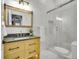 Modern bathroom features include natural wood vanity, stone countertop, large framed mirror, and glass shower at 1075 E Oxford Ln, Cherry Hills Village, CO 80113