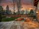 Backyard stone patio with a fire pit and stone bench seating at 1075 E Oxford Ln, Cherry Hills Village, CO 80113