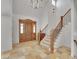 Grand foyer featuring a wooden door, staircase, and tile floor at 1075 E Oxford Ln, Cherry Hills Village, CO 80113