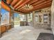 Outdoor covered patio with stone pillars, ceiling fan, barbecue, bar, and wood ceiling at 1075 E Oxford Ln, Cherry Hills Village, CO 80113