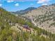 Secluded home nestled among trees on a hillside, featuring vibrant colors and surrounding mountainous scenery at 5896 Peregrine Trl, Golden, CO 80403