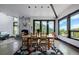 Elegant dining room with a fireplace and stunning mountain views through large windows at 5896 Peregrine Trl, Golden, CO 80403