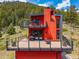 Unique red mountain home with expansive deck, perfect for enjoying the serene natural surroundings at 5896 Peregrine Trl, Golden, CO 80403