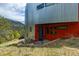 Modern home with metal and red facade, featuring a blue front door and mountain views at 5896 Peregrine Trl, Golden, CO 80403
