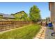 Grassy backyard with wood fence, trees, and access to a raised wood deck at 19259 E Caspian Pl, Aurora, CO 80013
