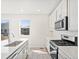 Modern kitchen with stainless steel appliances and white cabinetry at 8869 Sedalia St, Commerce City, CO 80022