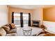 Inviting living room featuring a cozy couch, fireplace, and balcony access at 908 S Yampa St # 208, Aurora, CO 80017