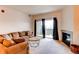Bright living room featuring a cozy couch, fireplace, and balcony access at 908 S Yampa St # 208, Aurora, CO 80017