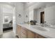 Bright bathroom with dual sinks, a large mirror, and modern fixtures, open to the bedroom at 12532 Daniels Gate Dr, Castle Pines, CO 80108