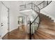 Elegant foyer with a curved staircase, hardwood floors, and a view into the formal dining room at 12532 Daniels Gate Dr, Castle Pines, CO 80108