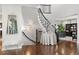 Charming foyer featuring hardwood floors, a curved staircase, and stylish decor at 12532 Daniels Gate Dr, Castle Pines, CO 80108