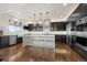 Modern kitchen with dark cabinets, marble countertops, and stainless steel appliances at 12532 Daniels Gate Dr, Castle Pines, CO 80108