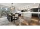 Open kitchen and dining area featuring a large island, modern lighting, and hardwood floors at 12532 Daniels Gate Dr, Castle Pines, CO 80108