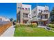 Modern townhomes boast sleek design with colorful doors and a well-maintained lawn at 1216 Perry St, Denver, CO 80204