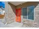 Exterior view of a brick home featuring an orange front door and a large window at 1216 Perry St, Denver, CO 80204