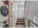 Hallway features modern washer and dryer, staircase with metal railing, and neutral carpet at 1216 Perry St, Denver, CO 80204