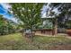 Exterior shot of the home and backyard featuring mature trees and raised garden beds at 3722 Monterey Pl, Boulder, CO 80301