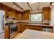 A well-lit kitchen featuring stainless steel appliances, light wood cabinets, and terra cotta flooring at 3722 Monterey Pl, Boulder, CO 80301
