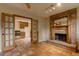 Living room area with terra cotta tile floors, fireplace and view to kitchen through open french doors at 3722 Monterey Pl, Boulder, CO 80301