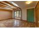 Inviting living room features terra cotta flooring, wood beam ceiling, a large window, and a green accent door at 3722 Monterey Pl, Boulder, CO 80301