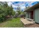 Concrete patio with grill outside of sliding glass door looking out at a green lawn with trees at 3722 Monterey Pl, Boulder, CO 80301