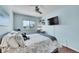 Bright bedroom featuring wood floors, ceiling fan, and TV at 4702 S Biscay Ct, Aurora, CO 80015