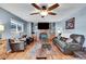 Inviting living room featuring a brick fireplace, ceiling fan, and plush leather seating at 4702 S Biscay Ct, Aurora, CO 80015