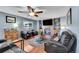 Cozy living room area features hardwood floors and a brick fireplace with a mounted TV at 4702 S Biscay Ct, Aurora, CO 80015