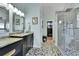 Luxurious bathroom with sleek vanity, tiled floors, and frameless glass walk-in shower at 4702 S Biscay Ct, Aurora, CO 80015