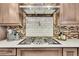 Modern kitchen featuring a stainless steel range and backsplash at 4702 S Biscay Ct, Aurora, CO 80015