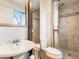 Bathroom featuring a pedestal sink, toilet, and tiled walk-in shower with a privacy curtain at 13561 W Alaska Pl, Lakewood, CO 80228