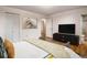 Well-lit bedroom featuring modern decor, a mounted TV, and a serene atmosphere with hardwood flooring at 13561 W Alaska Pl, Lakewood, CO 80228