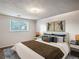 Comfortable bedroom featuring side tables, wall art, plush bedding, and natural light from the window at 13561 W Alaska Pl, Lakewood, CO 80228