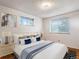 Cozy bedroom with soft, neutral tones, including plush bedding, decorative pillows, and a view from the window at 13561 W Alaska Pl, Lakewood, CO 80228
