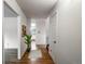 Inviting hallway featuring hardwood floors and neutral paint, leading to various rooms at 13561 W Alaska Pl, Lakewood, CO 80228