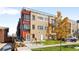 Modern townhome featuring a rooftop terrace, vibrant orange accents, and well-maintained landscaping at 1930 Grove St # 2, Denver, CO 80204