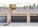 Exterior image showcasing the garages of modern townhomes, each with black doors and brick pillars at 1930 Grove St # 2, Denver, CO 80204