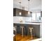 Modern kitchen featuring a spacious island with gold stools and designer pendant lights at 1930 Grove St # 2, Denver, CO 80204