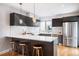 Modern kitchen island with bar seating, pendant lights, and stainless steel appliances at 1930 Grove St # 2, Denver, CO 80204