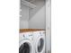 Convenient laundry room with modern washer and dryer and storage shelves at 1930 Grove St # 2, Denver, CO 80204