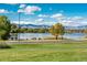 Scenic view of Sloan's Lake with walking path and distant mountains beneath a blue sky at 1930 Grove St # 2, Denver, CO 80204