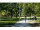 Paved pathway through a lush park with people walking and dogs at 1930 Grove St # 2, Denver, CO 80204