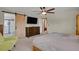 Bright bedroom features large television, ceiling fan, and barn door leading to modern bathroom at 3773 E Mineral Pl, Centennial, CO 80122